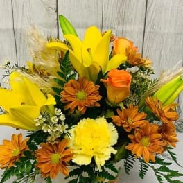Yellow lilies and orange daisies in a mixed bouquet