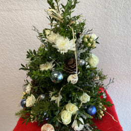 Christmas tree-shaped floral arrangement with white flowers and ornaments