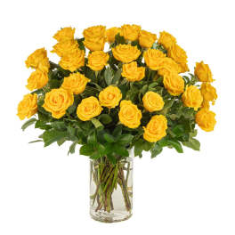 Large bouquet of yellow roses arranged in a clear glass vase