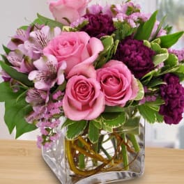 Pink and purple flower bouquet in a clear glass vase