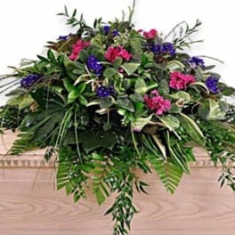 Large floral arrangement with pink and purple blooms and cascading greenery