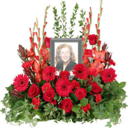 Red floral tribute with a framed portrait in the center