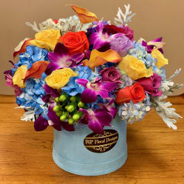Colorful bouquet in a light blue hat box with roses and orchids