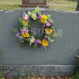 Colorful floral wreath on a gray gravestone