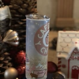 A tall insulated tumbler with a holiday coffee design.