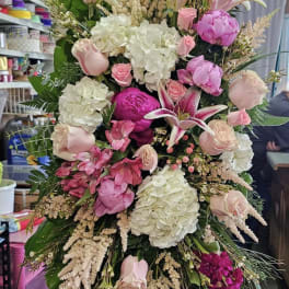 Tall standing floral spray with pink roses, lilies, and white hydrangeas