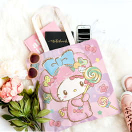 Gift bag with a pink flower, notebooks, sunglasses, phone, and pink sneakers