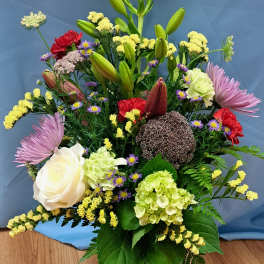 Mixed bouquet with lilies, roses, hydrangea, and chrysanthemums in a glass vase