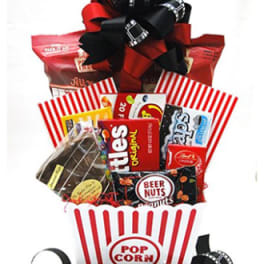 Gift basket with popcorn and assorted snack packages tied with a large ribbon