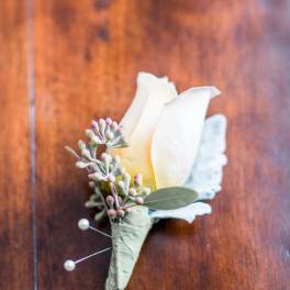 White calla lily boutonniere with small berry accents