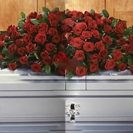 Red rose casket spray on a silver casket