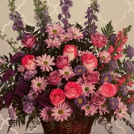 Pink roses and purple daisies in a wicker basket