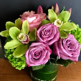 Pink roses and green orchids in a glass vase