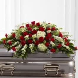 Red and white floral casket spray on a silver casket