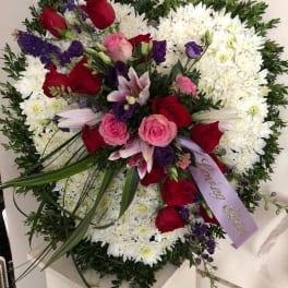 Large floral spray with red and pink roses, white chrysanthemums, and purple accents