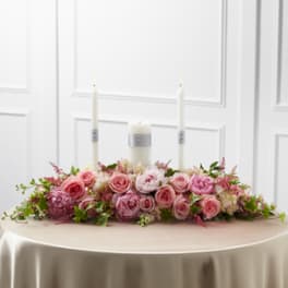 Pink rose centerpiece with candles on a table