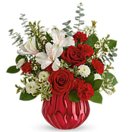 Red roses and white lilies in a red glass vase