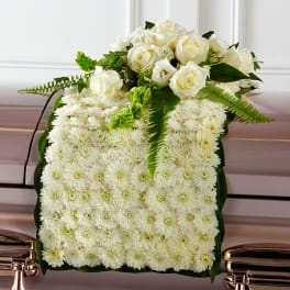 White rose and chrysanthemum arrangement on a casket