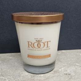 White candle in a glass jar with a copper lid