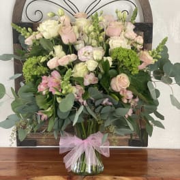 Bouquet of pink and white roses with greenery in a glass vase