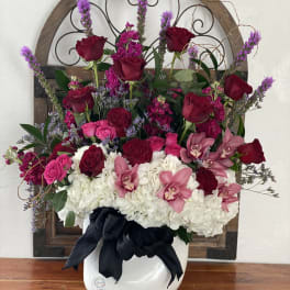 Pink and red roses with white hydrangeas in a white vase