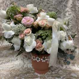 Bouquet of white and blush flowers in a decorated terracotta pot