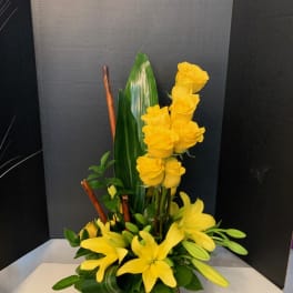 Yellow roses and lilies arranged in a basket