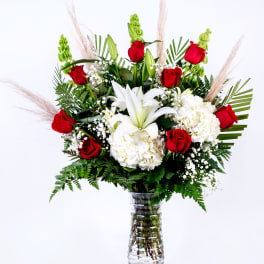 Red roses and white lilies in a clear glass vase