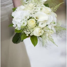 Bridal hand-tied bouquet of white roses, calla lilies, and soft ivory blooms.