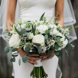 Bride holding a white bouquet with green foliage