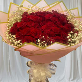 Large bouquet of red roses with baby's breath in pink wrap