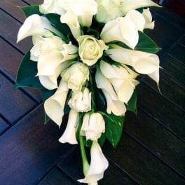 White calla lily and rose bridal bouquet with dark green leaves