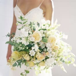 Bride holding a large white and pale yellow bouquet
