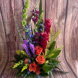 Tall mixed bouquet with orange roses and bright tropical blooms