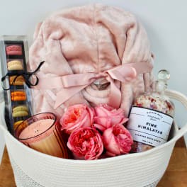 Gift basket with pink blanket, macarons, roses, candle, and bath salts