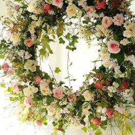 Large circular floral wreath with pink and white roses
