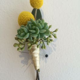 Succulent boutonniere with yellow pom-pom accents and cream ribbon wrap