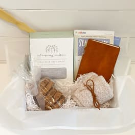 Gift basket with a neck wrap, notebook, cookies, and a small pouch