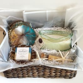 Gift basket with soap, candle, and bath items in a woven basket