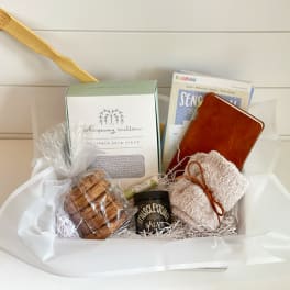 Gift basket with soap, cookies, a tin, and a towel