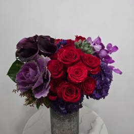 Red and purple rose arrangement in a silver vase