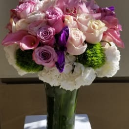 Pink and white rose bouquet in a tall glass vase