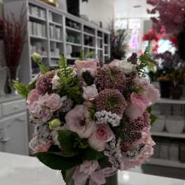 Pink mixed flower bouquet in a dark glass vase