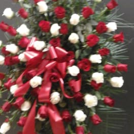 Large standing spray of red and white roses with red ribbon