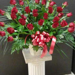 Large bouquet of red roses with a red ribbon bow in a white vase