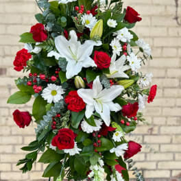 Standing floral spray with red roses, white lilies, and daisies