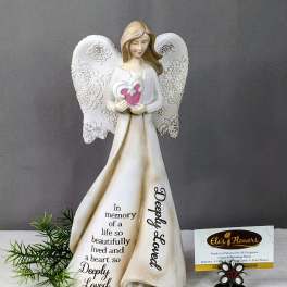Angel figurine holding a heart with a memorial message on her dress