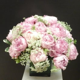 Pink peony bouquet in a square glass vase