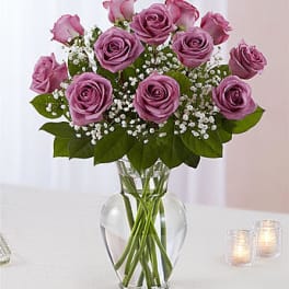 Pink roses arranged in a clear glass vase with baby's breath