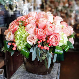 Pink roses and hydrangeas arranged in a dark vase